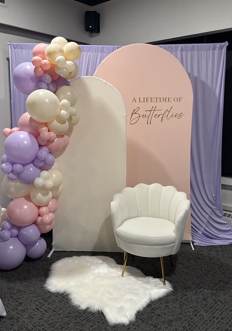 Pastel balloon garland on a cream arch panel at an outdoor Winnipeg party